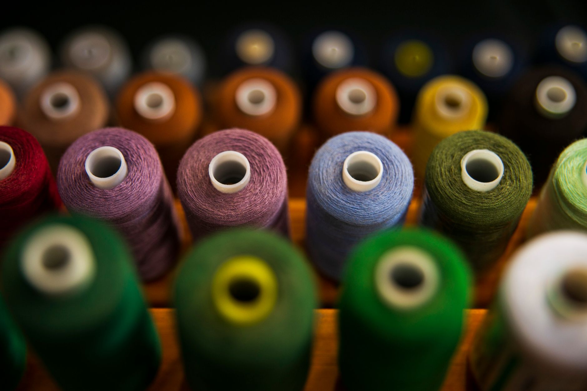 Wall of thread spools in the shop's four dye colors